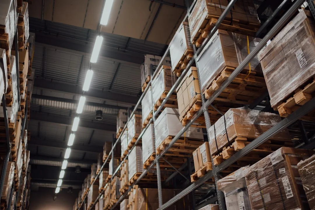 Shrink-wrapped pallets of cartons on warehouse racking several levels high